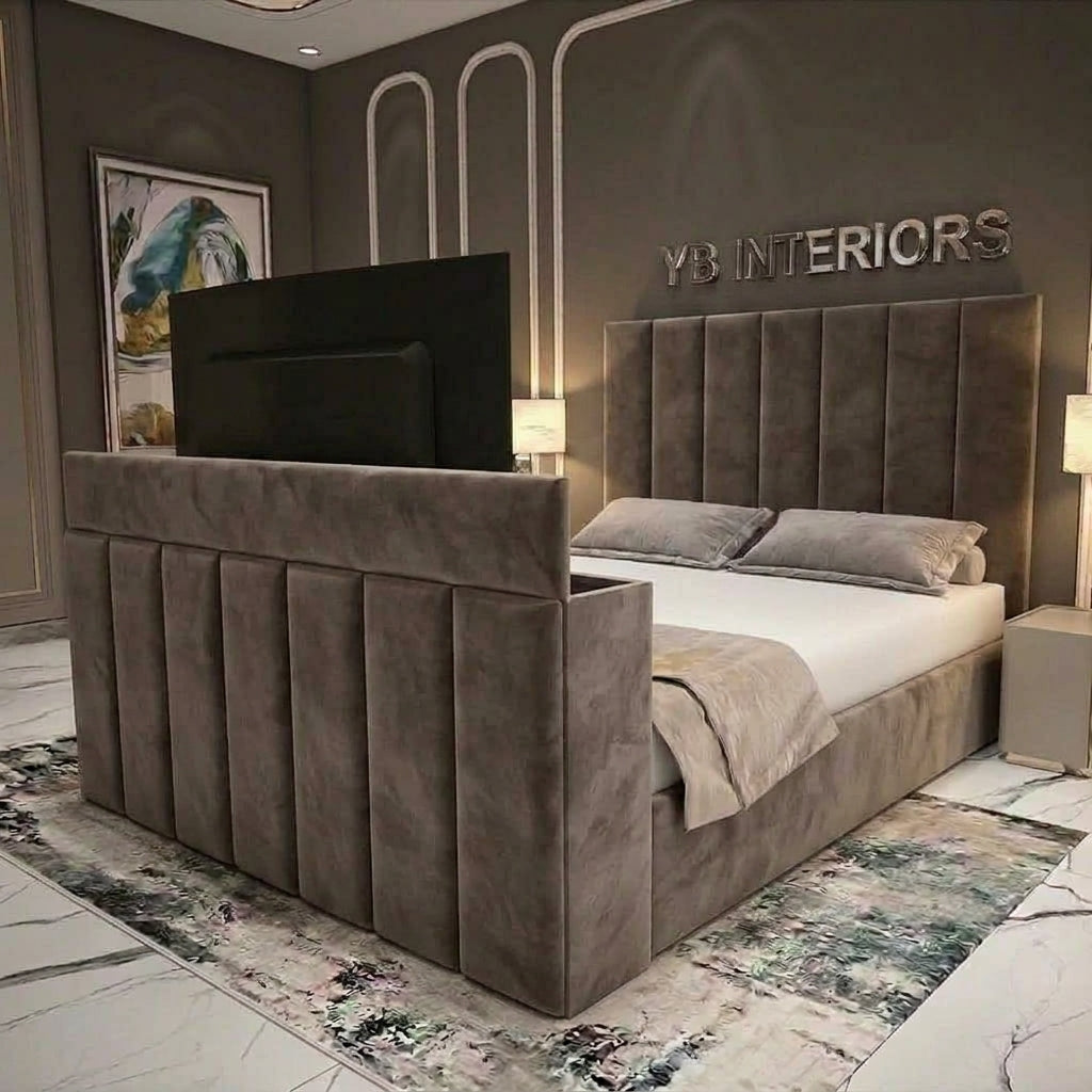A modern upholstered bed frame in taupe velvet, shown in a styled bedroom setting. The bed features a tall, segmented headboard and matching footboard, styled with white bedding, a beige throw blanket, and a patterned rug.