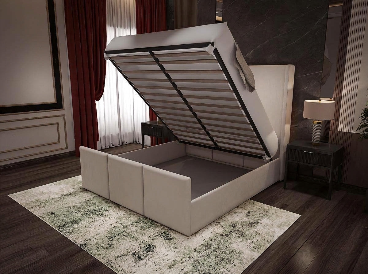 A modern upholstered storage bed with a lift-up headboard, shown in a styled bedroom setting with dark wood flooring, red curtains, and a patterned rug.