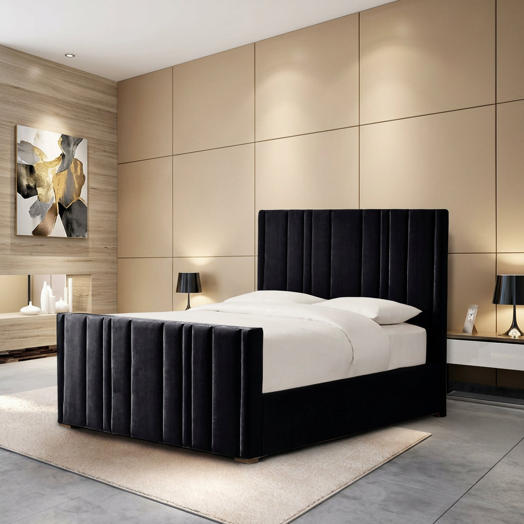 A modern black upholstered bed frame with a tall channel-tufted headboard and matching footboard, shown in a styled bedroom setting with beige paneled walls, bedside tables, lamps, and white bedding.