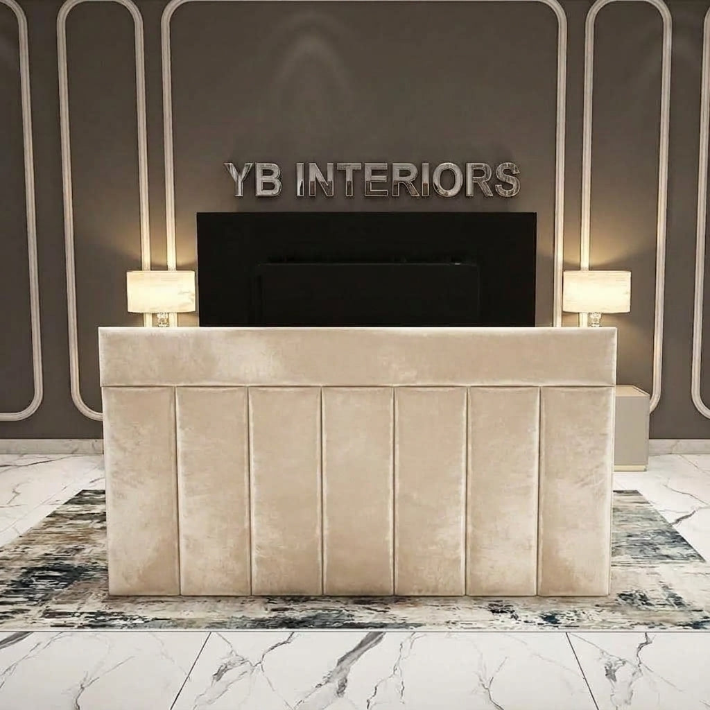 A modern cream velvet reception desk with vertical channel tufting, set against a dark gray wall with decorative white lines and the text 'YB INTERIORS'.
