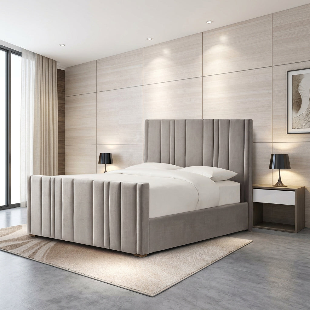 A modern upholstered bed with a tall channel-tufted headboard and matching footboard, shown in a styled bedroom setting with light wood paneled walls, bedside tables, lamps, and a rug.