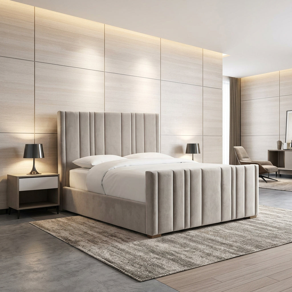 A modern upholstered bed with a tall channel-tufted headboard and matching footboard, shown in a styled bedroom with light wood paneled walls, bedside tables, lamps, a rug, and a chair in the background.