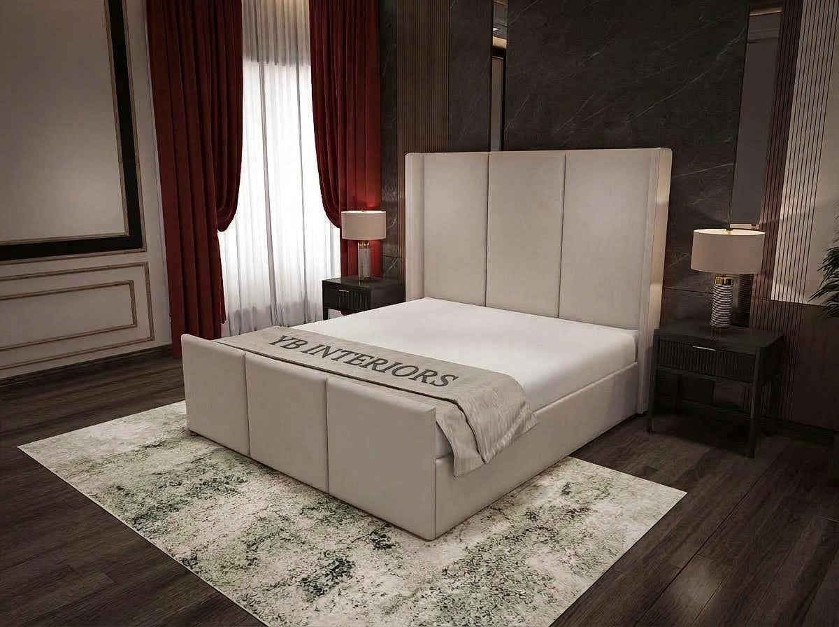 A modern upholstered bed with a tall segmented headboard and matching footboard, shown in a styled bedroom. The bed is dressed in white bedding with a gray throw blanket that reads 'YI INTERIORS'.