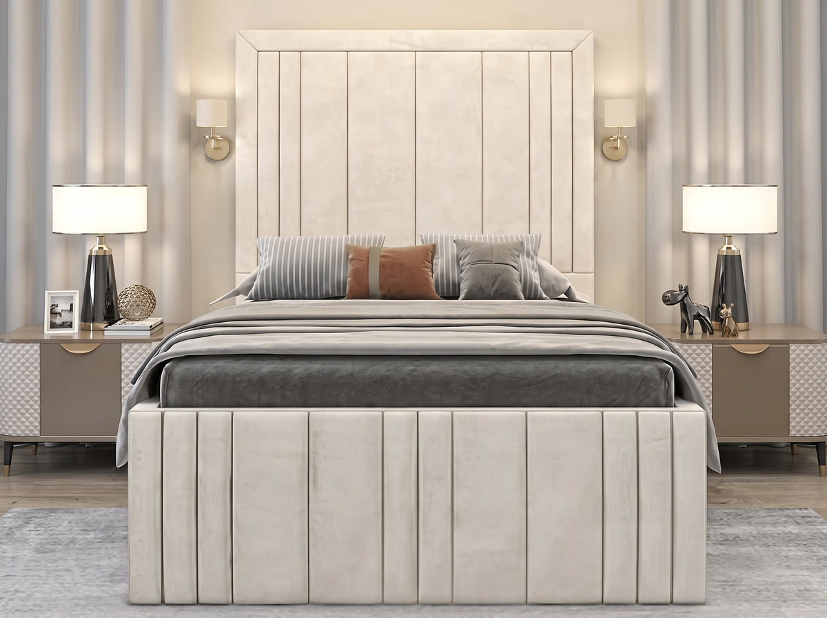 A modern upholstered bed with a tall vertical slat headboard and matching slatted footboard, styled in a symmetrical bedroom with gray bedding, striped and rust accent pillows, bedside tables, lamps, and striped wallpaper.